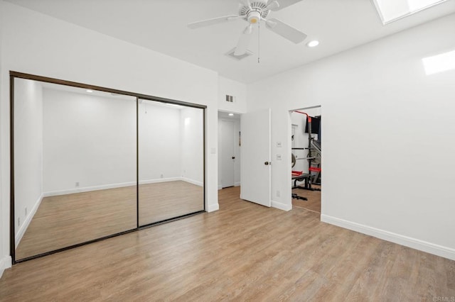 unfurnished bedroom with baseboards, visible vents, light wood finished floors, a skylight, and recessed lighting