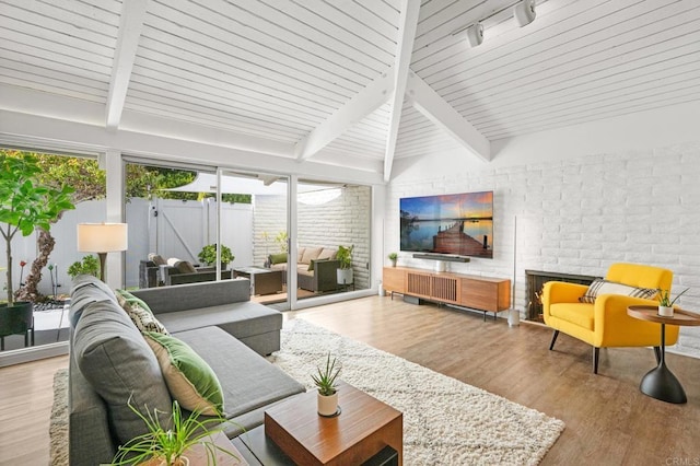 sunroom featuring lofted ceiling with beams and track lighting