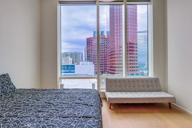 bedroom featuring a view of city and wood finished floors