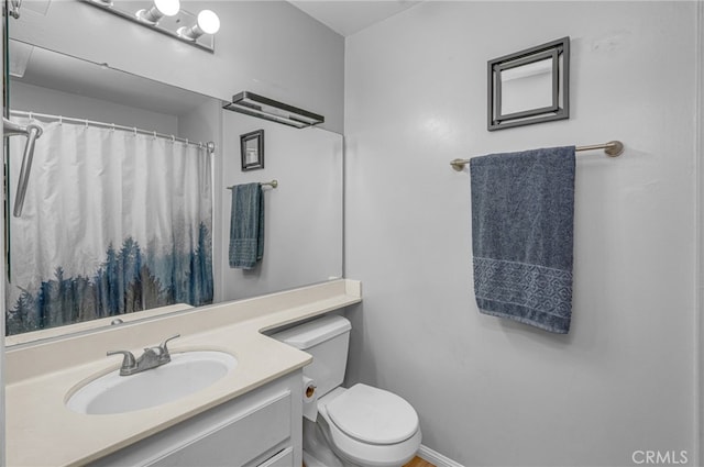 bathroom featuring a shower with shower curtain, toilet, and vanity