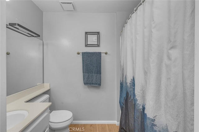 full bath with vanity, wood finished floors, visible vents, baseboards, and toilet