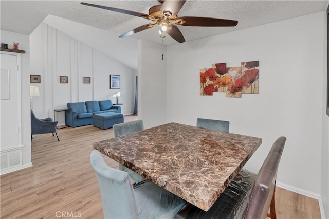 dining space with ceiling fan, visible vents, light wood finished floors, and a textured ceiling