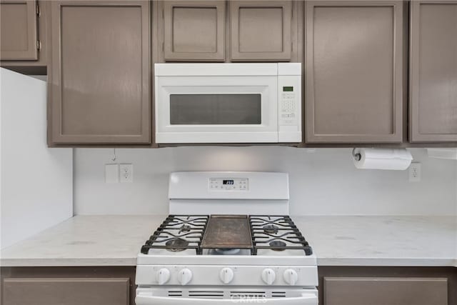 kitchen featuring white appliances and light stone countertops