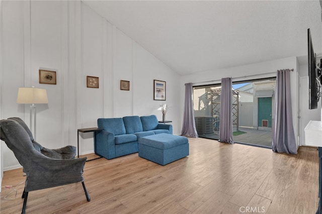 living room with high vaulted ceiling and wood finished floors