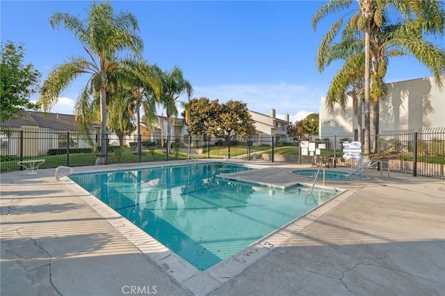 community pool featuring a patio area and fence