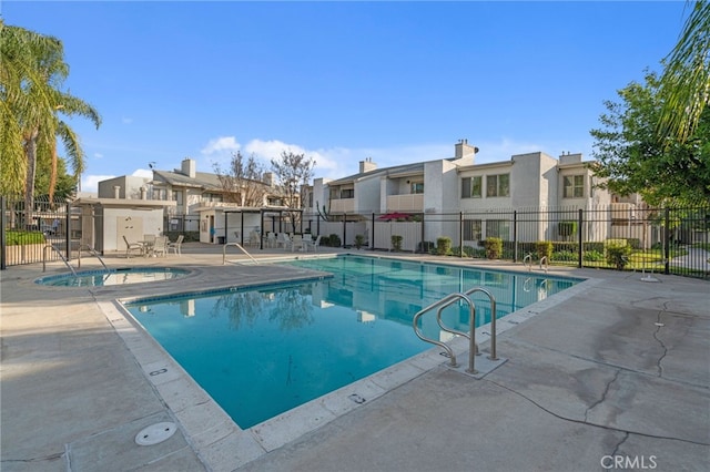 pool with a residential view, a patio, and fence