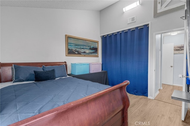 unfurnished bedroom with visible vents, light wood finished floors, and a textured ceiling