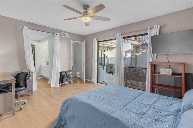 bedroom featuring a ceiling fan, baseboards, wood finished floors, visible vents, and a textured ceiling