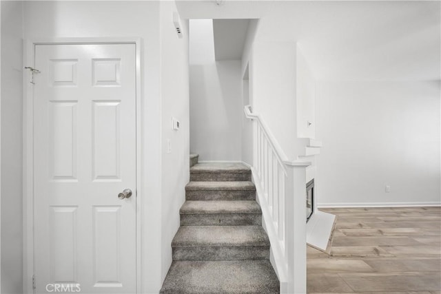 stairway with baseboards and wood finished floors