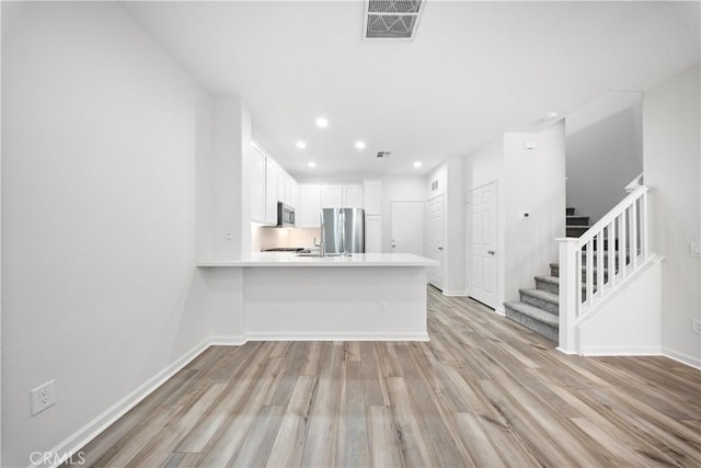 unfurnished living room featuring stairway, baseboards, visible vents, light wood-style flooring, and recessed lighting