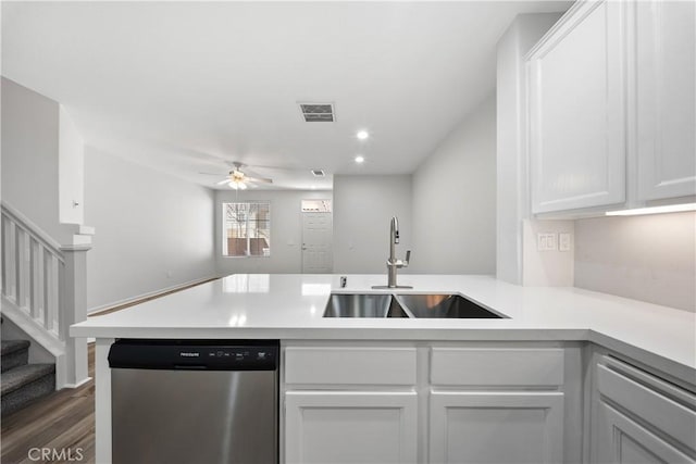 kitchen featuring visible vents, a sink, stainless steel dishwasher, a peninsula, and light countertops