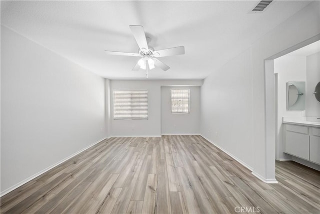 unfurnished bedroom with baseboards, visible vents, light wood finished floors, ensuite bath, and ceiling fan