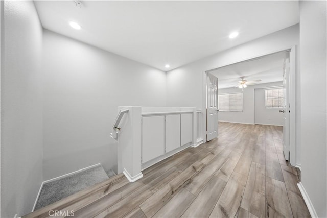 corridor featuring recessed lighting, baseboards, and light wood-style floors