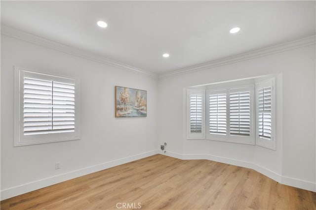 unfurnished room featuring baseboards, light wood-style floors, and crown molding