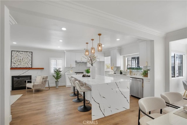 kitchen featuring a center island, crown molding, dishwasher, decorative backsplash, and white cabinets