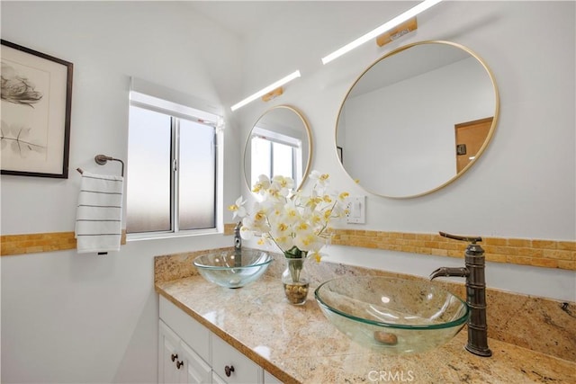 full bath with double vanity and a sink