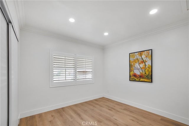 empty room with light wood-style floors, baseboards, and ornamental molding