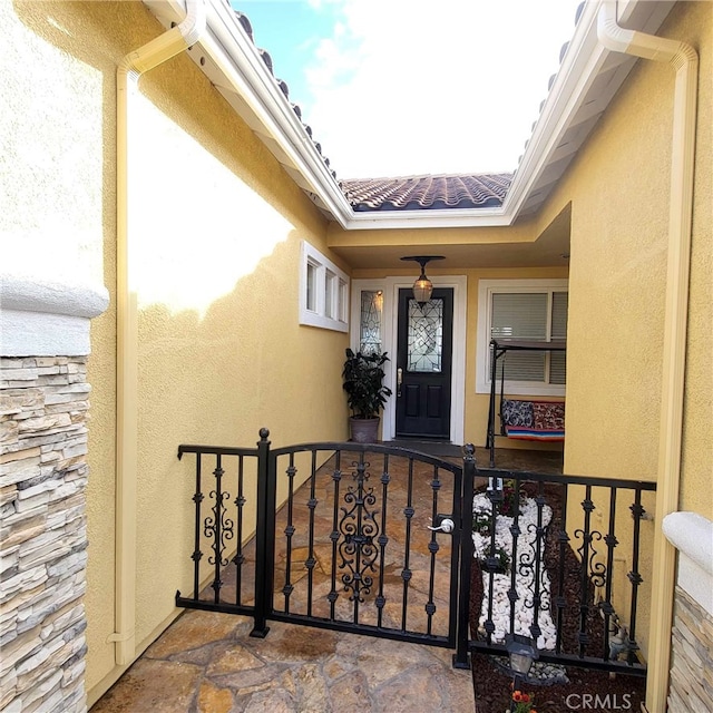 property entrance with stucco siding and stone siding