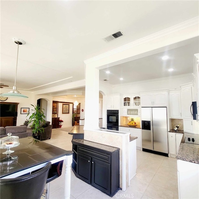 kitchen with stainless steel fridge with ice dispenser, visible vents, open floor plan, and arched walkways
