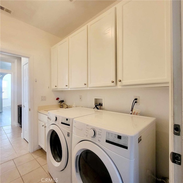 laundry area with cabinet space, visible vents, washing machine and dryer, and light tile patterned flooring