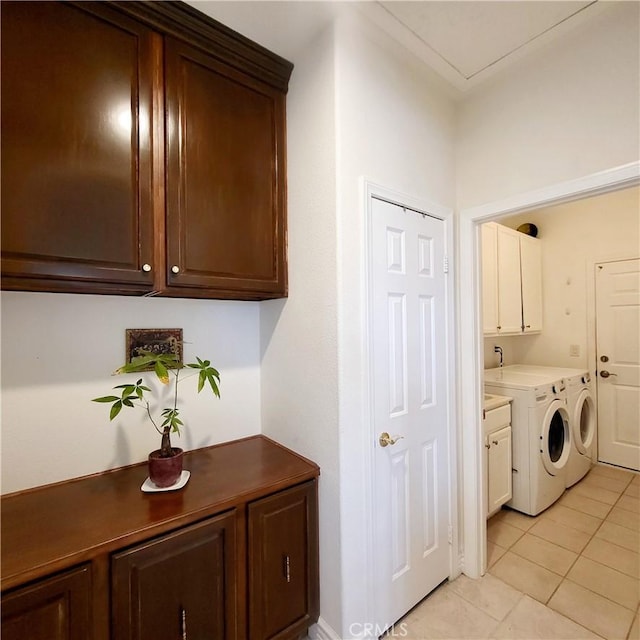 washroom with washer and dryer, light tile patterned floors, and cabinet space