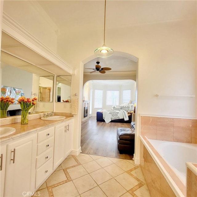 bathroom featuring a sink, ensuite bathroom, ceiling fan, and tile patterned flooring