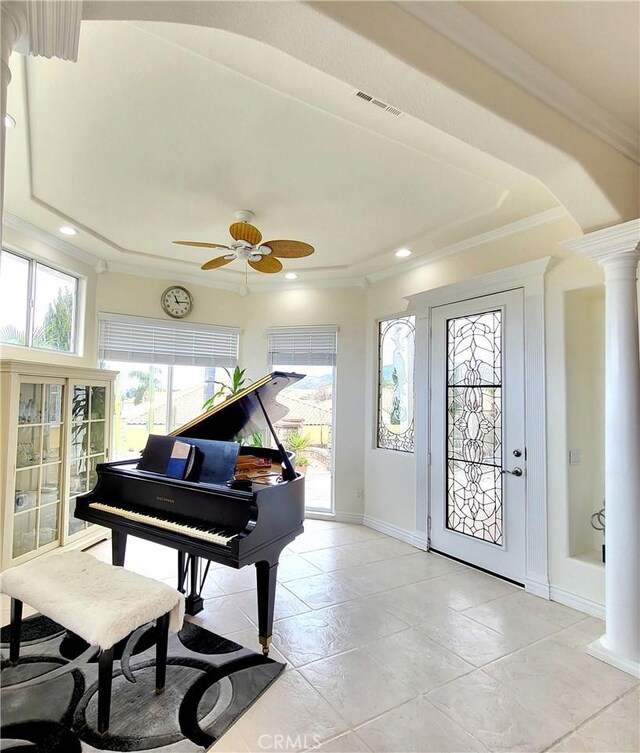 sitting room featuring visible vents, baseboards, ceiling fan, decorative columns, and crown molding