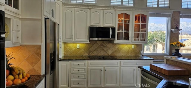 kitchen featuring dark stone countertops, white cabinetry, and appliances with stainless steel finishes