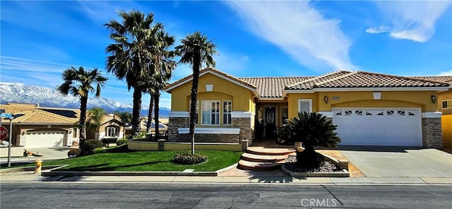 view of front of house featuring stucco siding, stone siding, a mountain view, and a tile roof