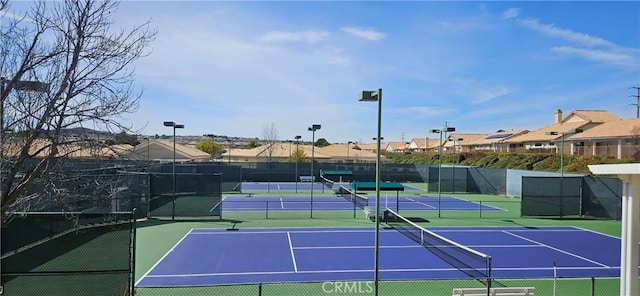 view of tennis court with a residential view, fence, and community basketball court