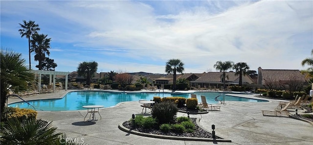 community pool with a pergola and a patio