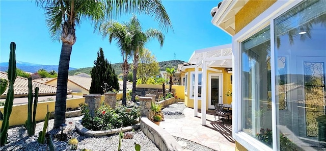 view of patio with fence and a mountain view