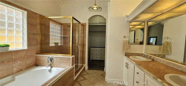 full bath with a bath, tile patterned floors, a sink, and a shower stall
