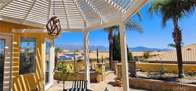 view of patio featuring a pergola, fence, and a mountain view