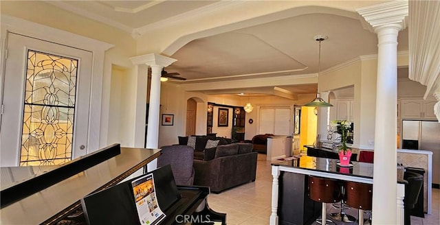 interior space with arched walkways, light tile patterned flooring, ornate columns, ceiling fan, and crown molding