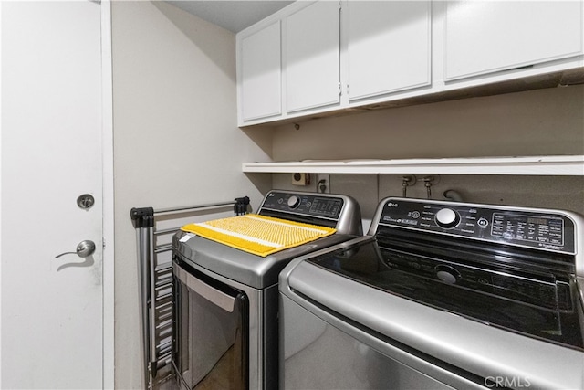 washroom featuring cabinet space and washing machine and dryer