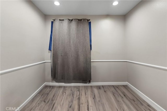 spare room with recessed lighting, baseboards, and wood finished floors