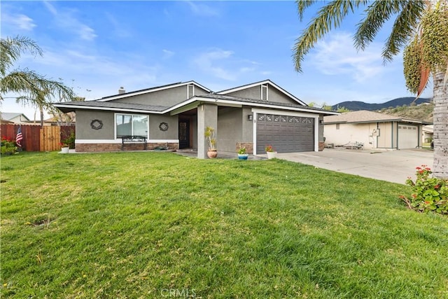 view of front of house with stucco siding, fence, concrete driveway, a front yard, and a garage