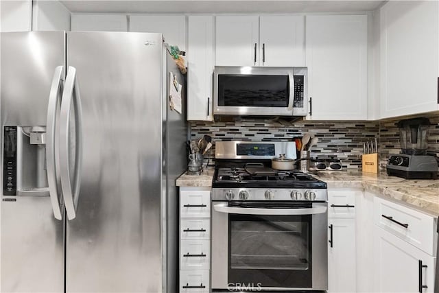 kitchen featuring light stone counters, tasteful backsplash, appliances with stainless steel finishes, and white cabinetry