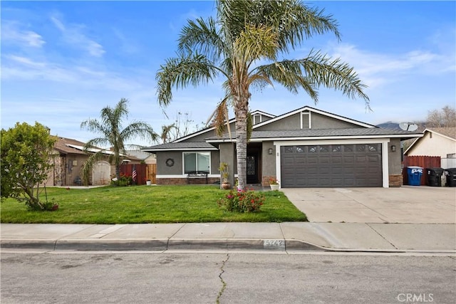 view of front of property featuring a front lawn, fence, concrete driveway, stucco siding, and an attached garage