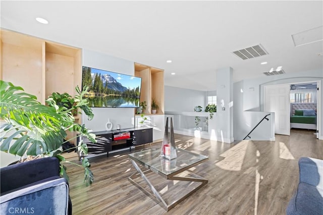 living area with recessed lighting, wood finished floors, and visible vents