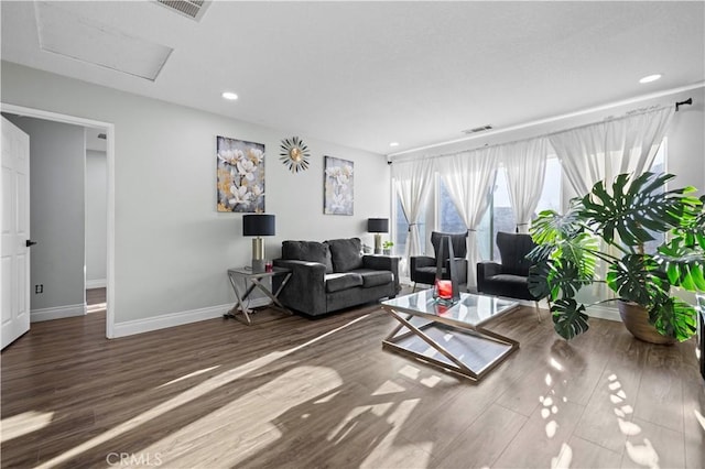 living room with visible vents, attic access, and wood finished floors