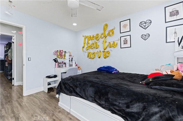 bedroom with a ceiling fan, baseboards, and wood finished floors