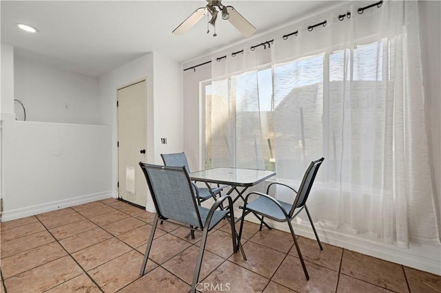 tiled dining space with a wealth of natural light, baseboards, and ceiling fan