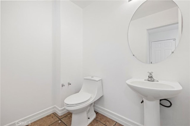 bathroom with tile patterned flooring, toilet, and baseboards