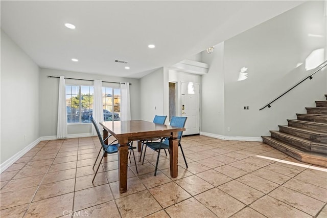 dining area featuring stairway, baseboards, visible vents, and light tile patterned flooring