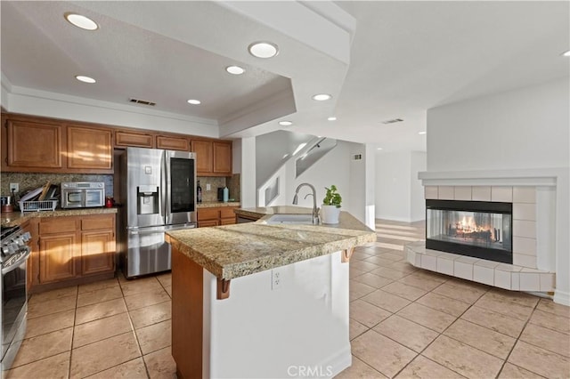 kitchen with a sink, visible vents, brown cabinets, and appliances with stainless steel finishes