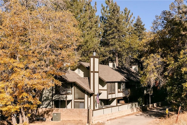 view of side of property featuring roof with shingles and a chimney