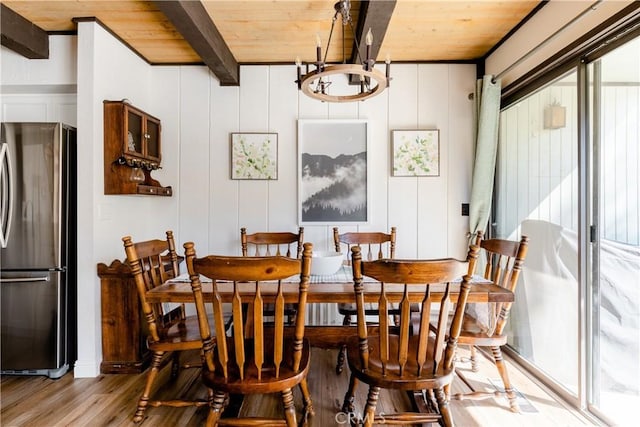 dining room featuring beam ceiling, wood finished floors, wood ceiling, and a chandelier