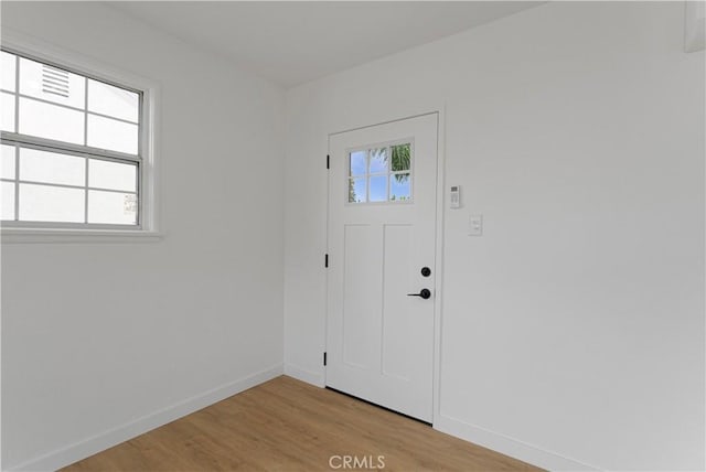 foyer featuring light wood-style floors and baseboards